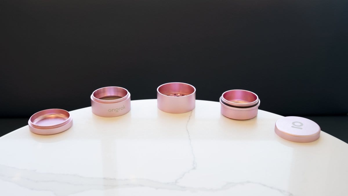 A top-down view of the 5 Piece Storage Grinder set, arranged on a light surface with a clean, minimalist aesthetic.