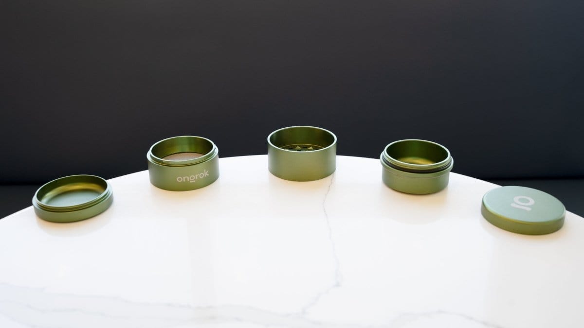 A top-down view of the 5 Piece Storage Grinder set, arranged in a circular pattern on a white surface.
