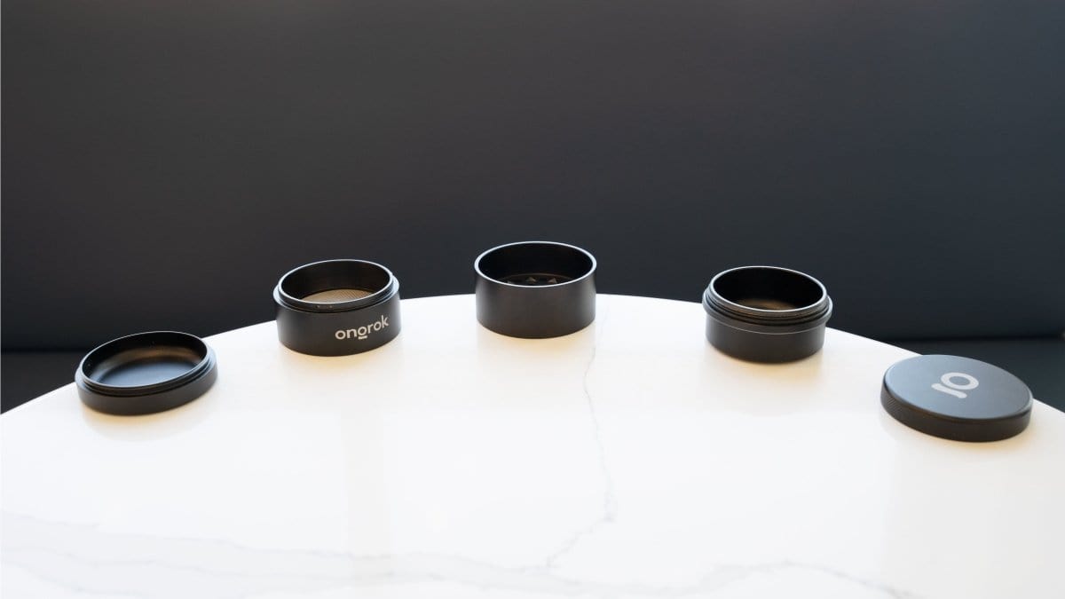 A top-down view of the 5 Piece Storage Grinder collection, arranged in a circular pattern on a light-colored surface.