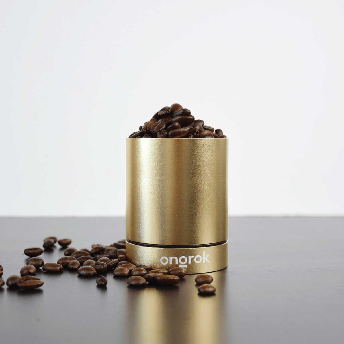 A low-angle shot of the Aluminum Metal Storage Jar, displaying a reflective metallic surface surrounded by scattered dark objects.