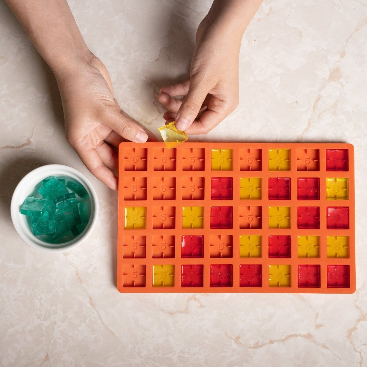 A top-down view shows the Scored Gummy Molds filled with colorful, translucent candies, showcasing a grid pattern.