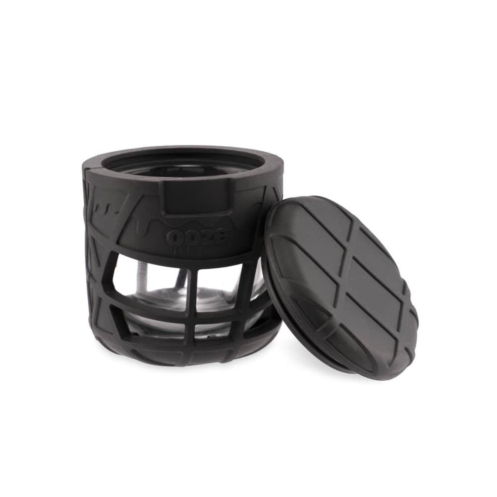 The Ooze Prizm Silicone-Wrapped Glass Stash Jar is shown from above, with the lid slightly ajar, revealing the empty glass interior.