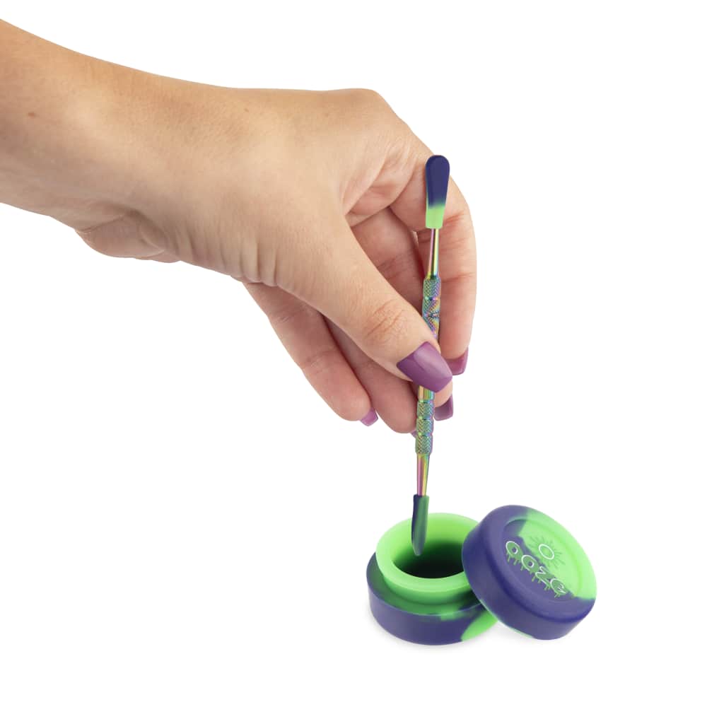 A hand holds the Ooze Fusion Atomizer Vape Battery, showcasing its sleek, metallic design against a muted background.