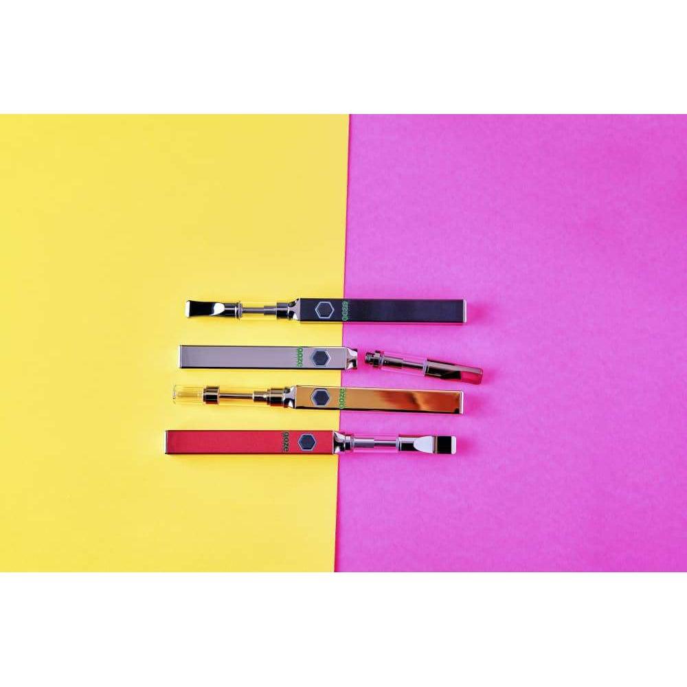 A slightly angled studio shot of the Ooze Quad 510 Thread 500 mAh Square Vape Pen Battery on a vibrant pink and blue background.