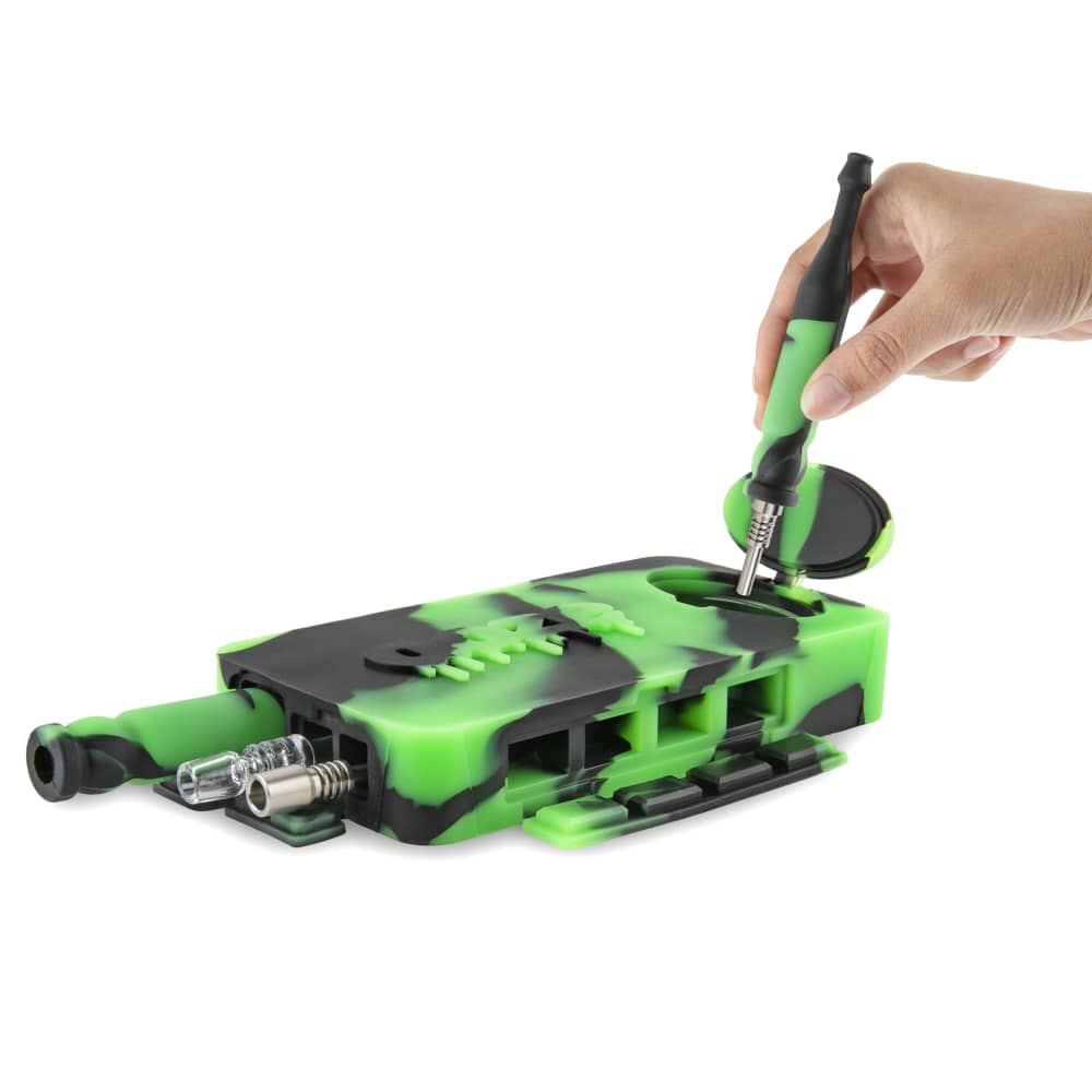 A hand opens the Ooze Slugger Silicone Dugout, revealing a small compartment within the dark grey, rectangular container.