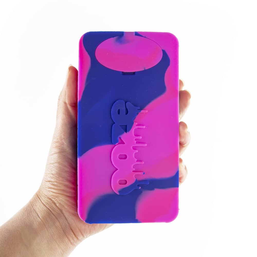 A hand holds the Ooze Slugger Silicone Dugout, showing its dark blue, rounded shape and simple design.