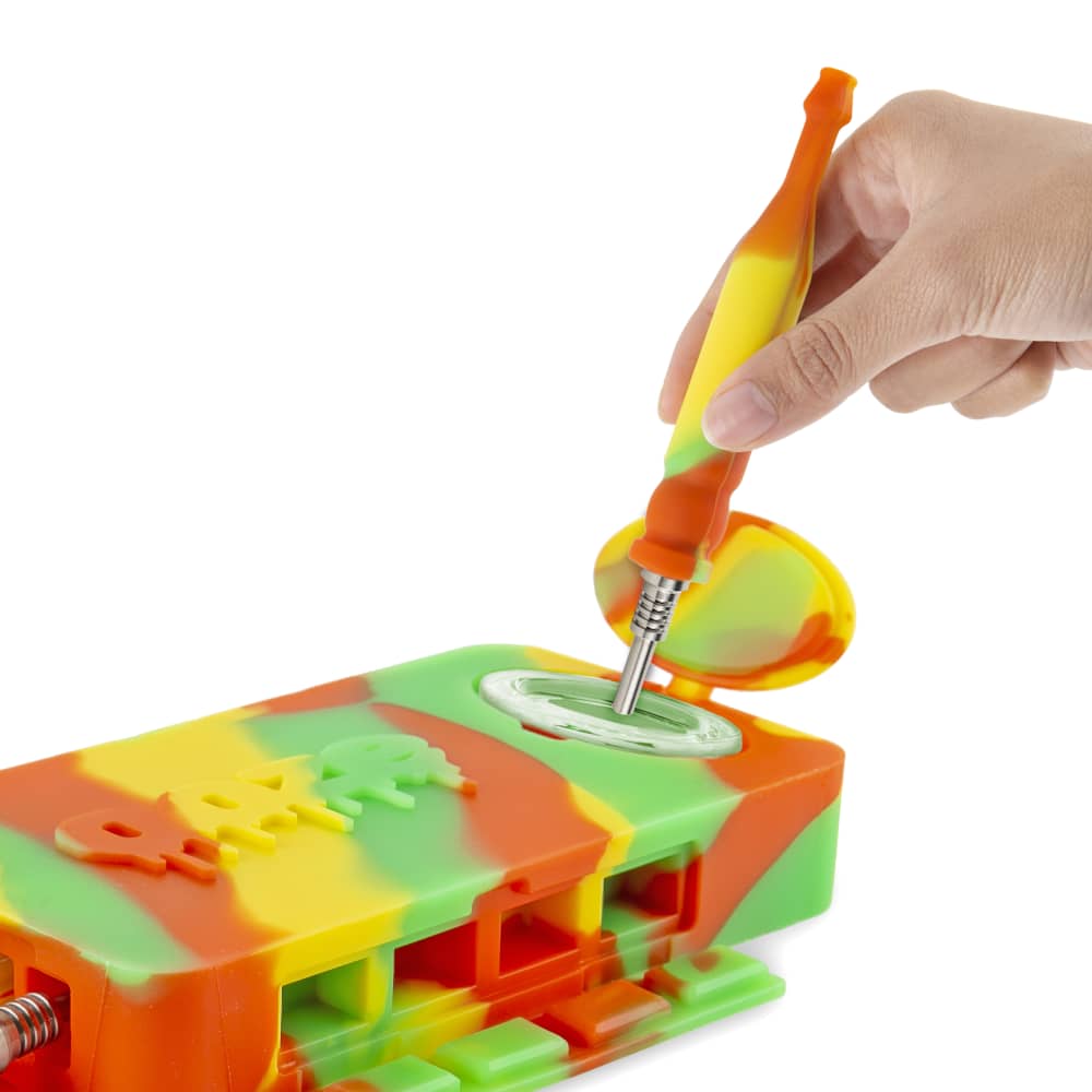 A close-up shot of the Ooze Slugger Silicone Dugout with a tool inserted into its opening, viewed from above.