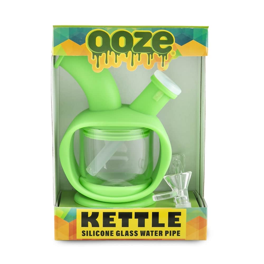 Front view of the Ooze Kettle Silicone Bubbler, a clear glass piece with a rounded shape and branded packaging visible behind it.