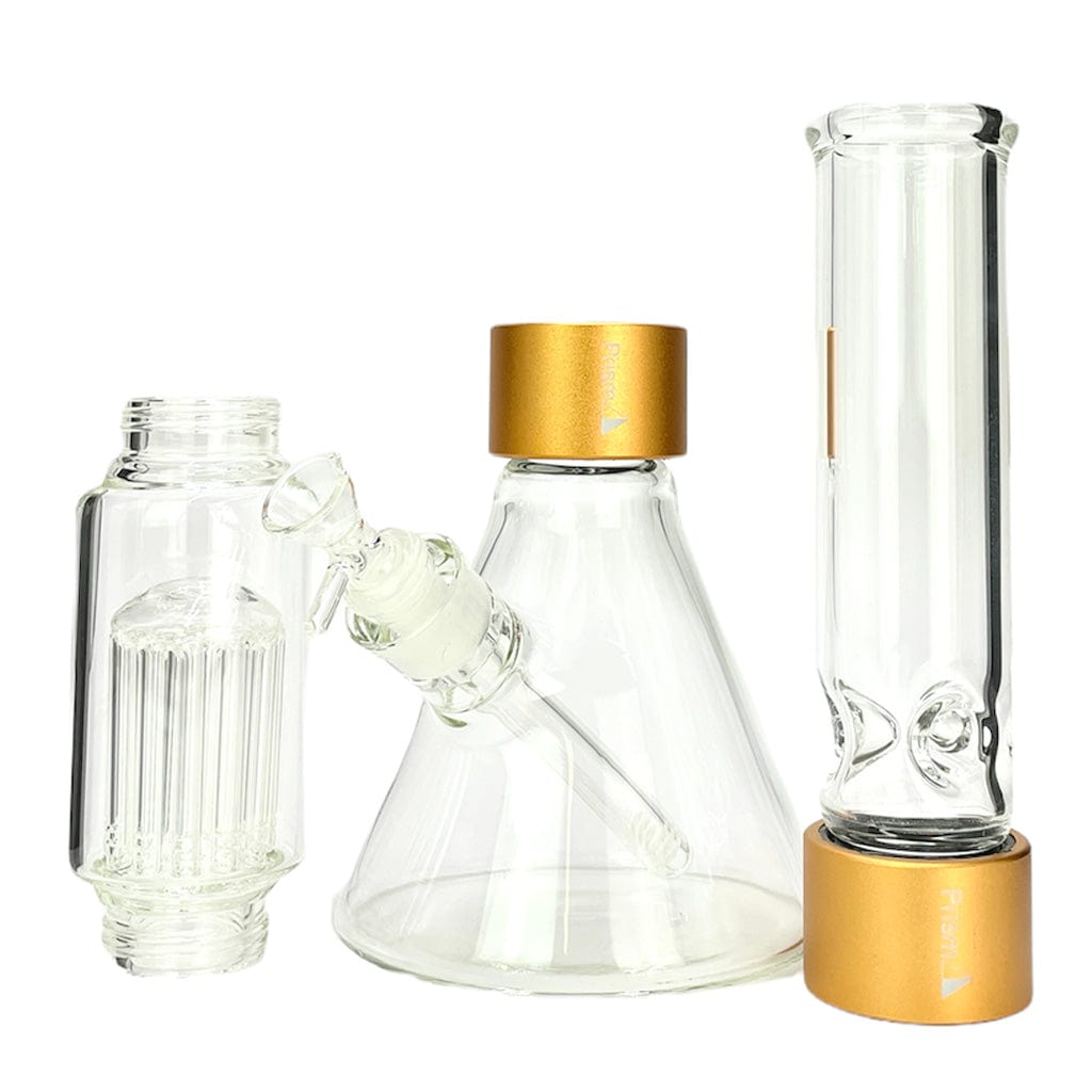 Three-quarter view of the Prism Beaker Double Stack showing clear glass components with gold-colored caps against a white background