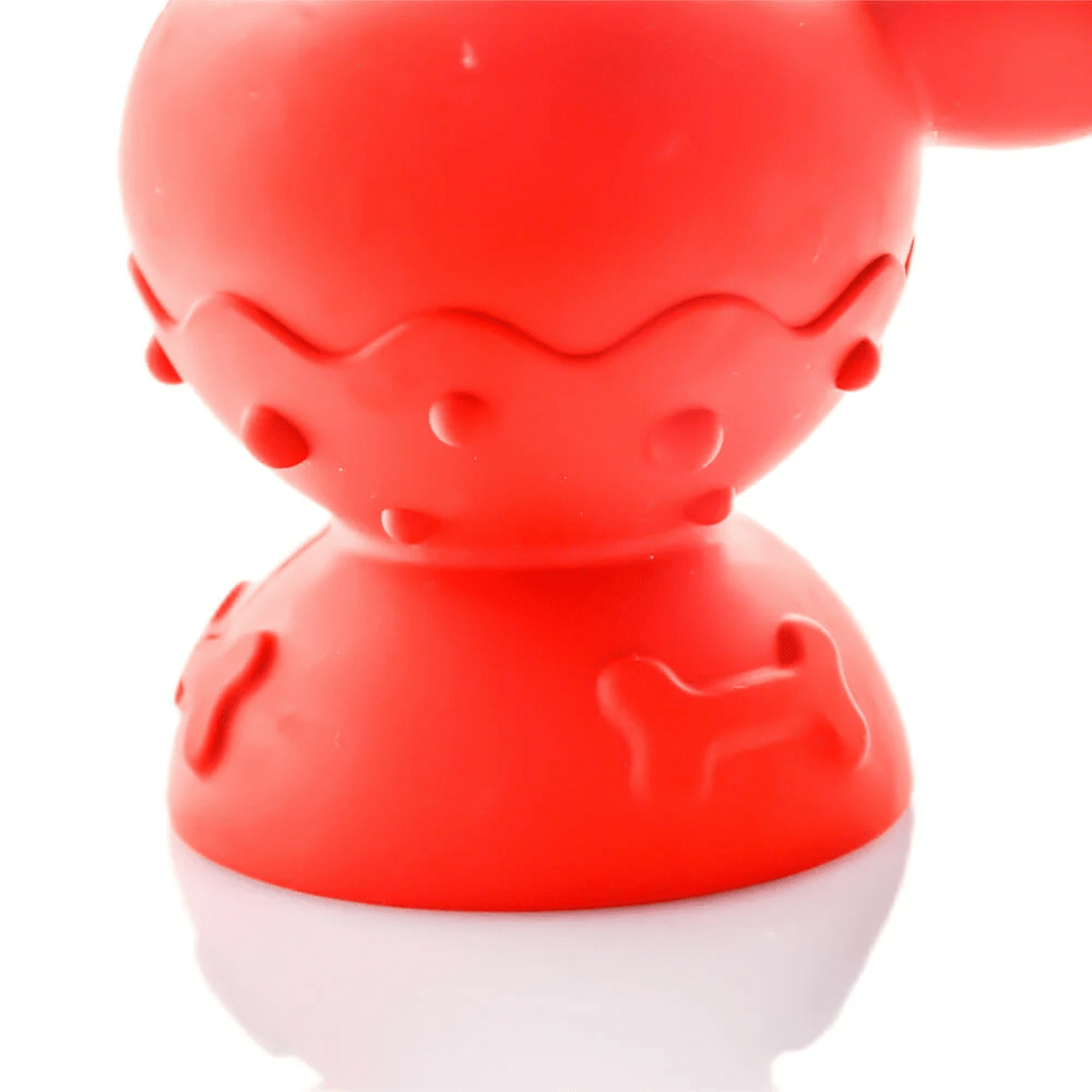 Close-up front view of the red Tug & Toke toy showing textured bumps and bone-shaped raised patterns on a glossy white background
