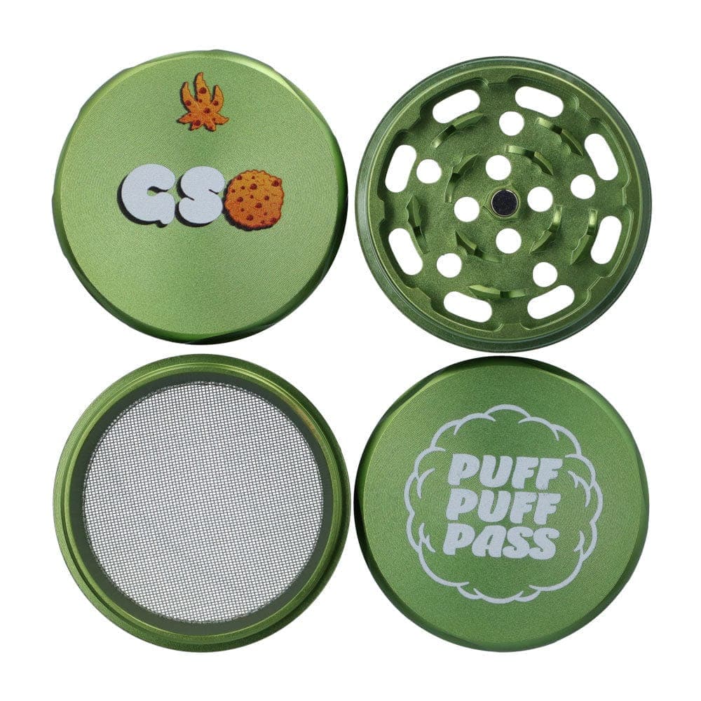 Top-down view of the green GSC 55mm 3-Stage Grinder showing its four separated pieces: printed lid, toothed grinding plate, mesh screen, and bottom catcher.