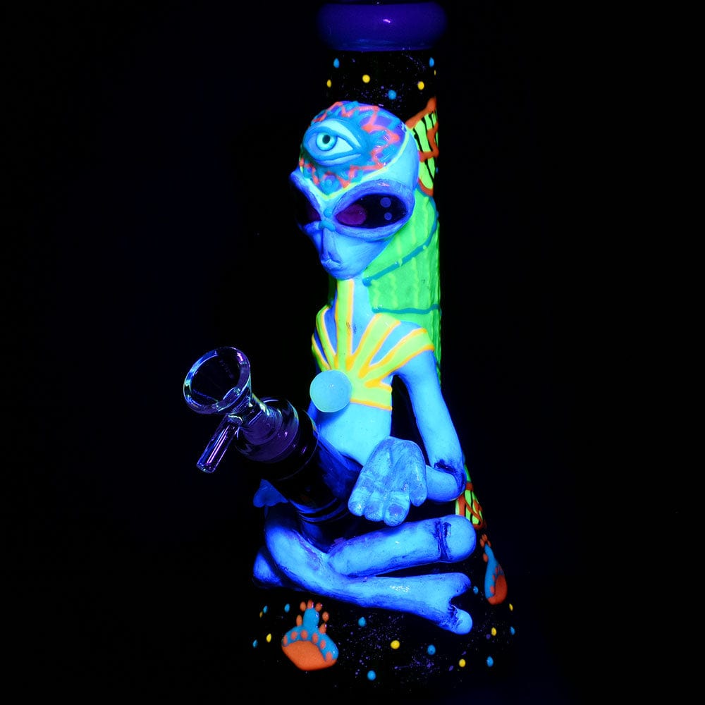 Front view of the Pulsar Artist Series Glow Beaker Water Pipe with a glowing blue alien figure design against a dark background.