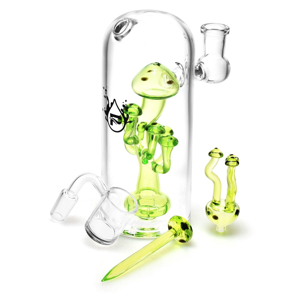 A close-up shows the Pulsar Mushroom Dab Rig Kit with a small, clear glass rig and accompanying dab nail, viewed from a slightly elevated angle.