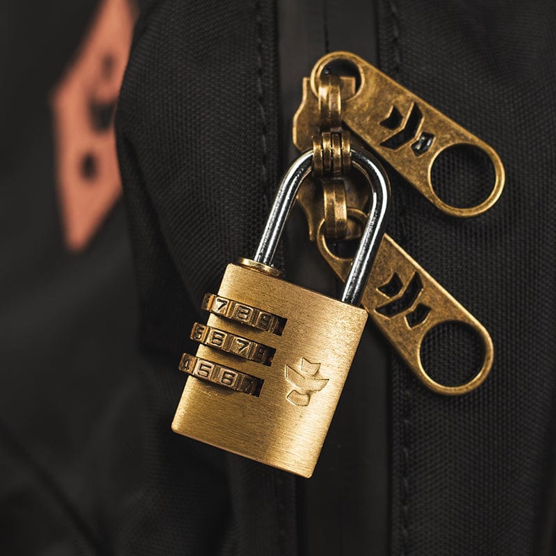 Close-up, angled view of The Explorer - Smell Proof Backpack’s zipper pull against a dark, textured fabric background.