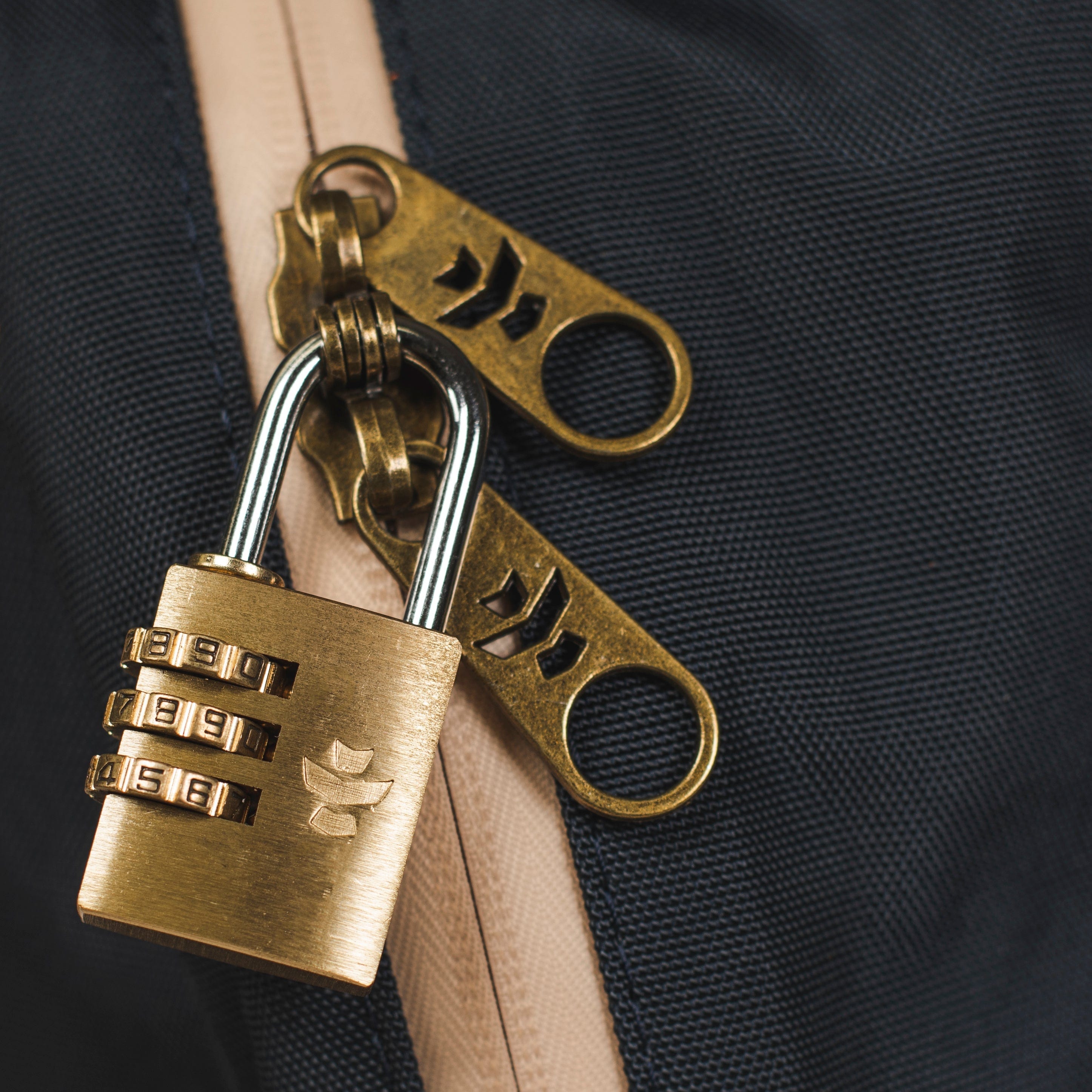 Close-up view of The Explorer - Smell Proof Backpack’s zipper pull against a dark, textured backdrop.