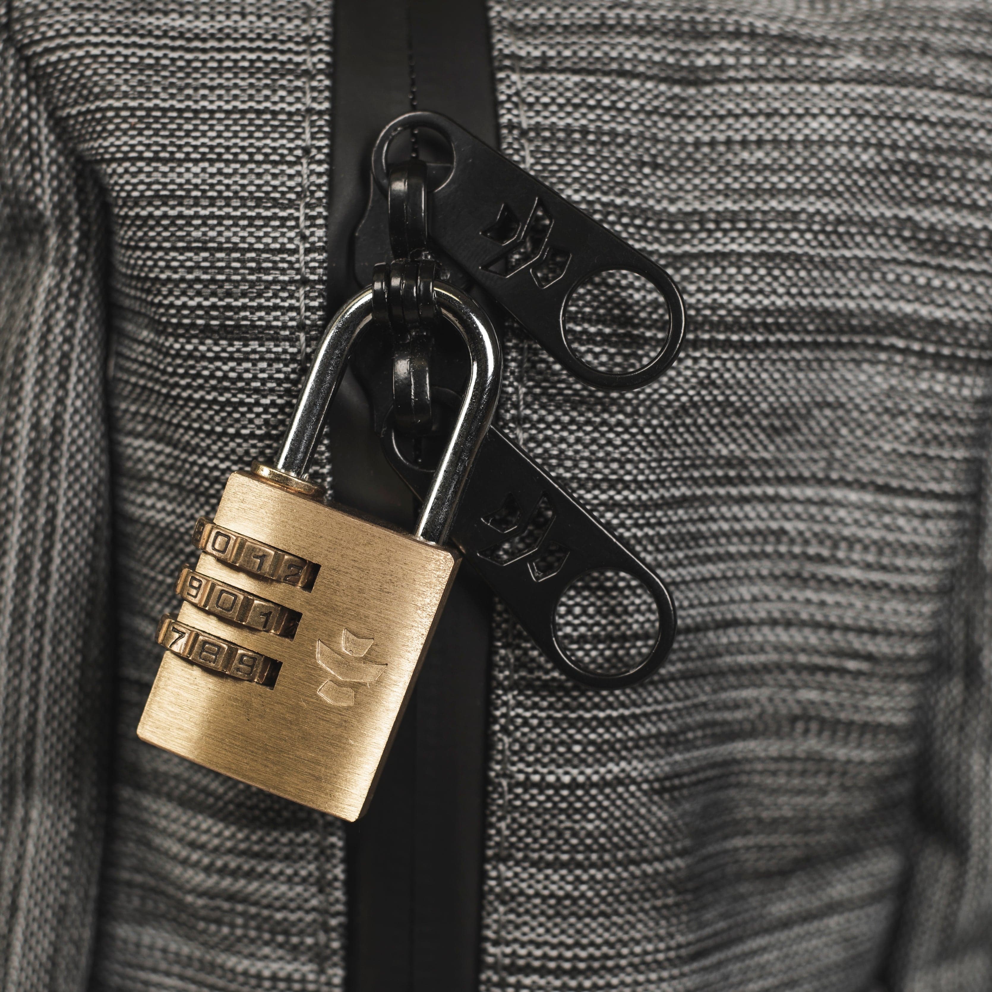 Close-up view of The Explorer - Smell Proof Backpack’s zipper pull against a textured dark gray background.