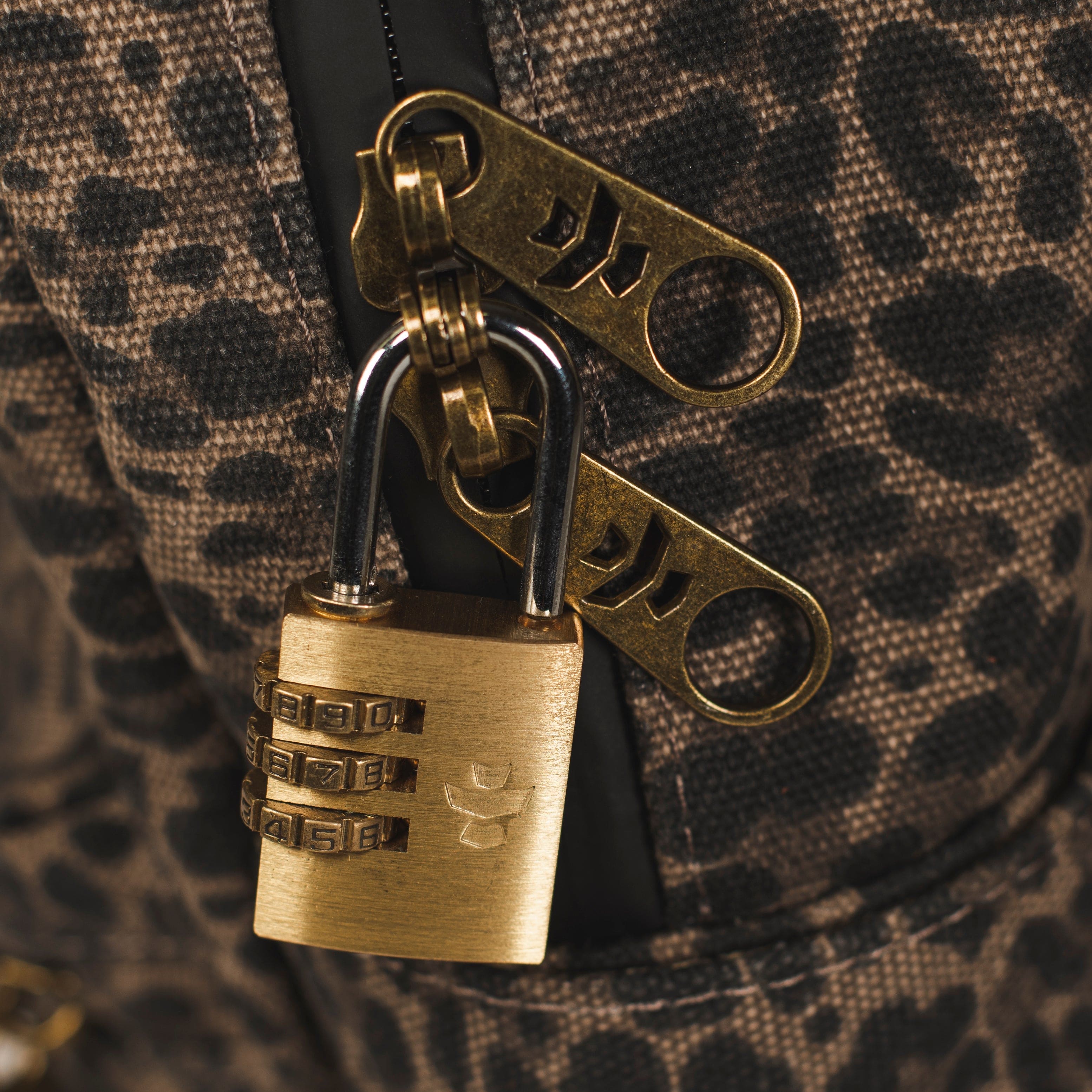 Close-up of The Explorer - Smell Proof Backpack zipper pull, featuring a dark, textured surface and metallic accents.