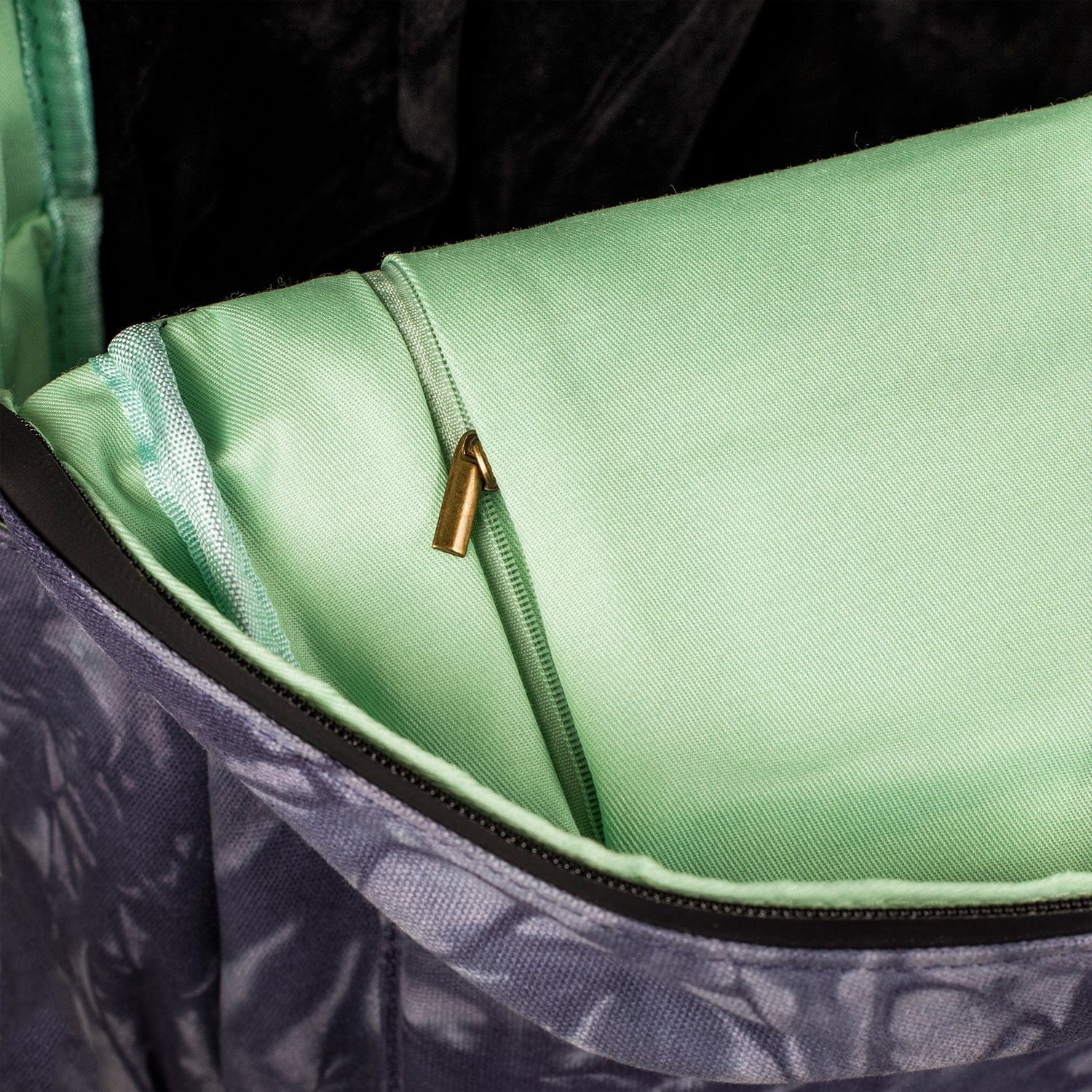 Interior view of The Explorer - Smell Proof Backpack, showing a partially open, dark-colored zipper against a vibrant green lining.