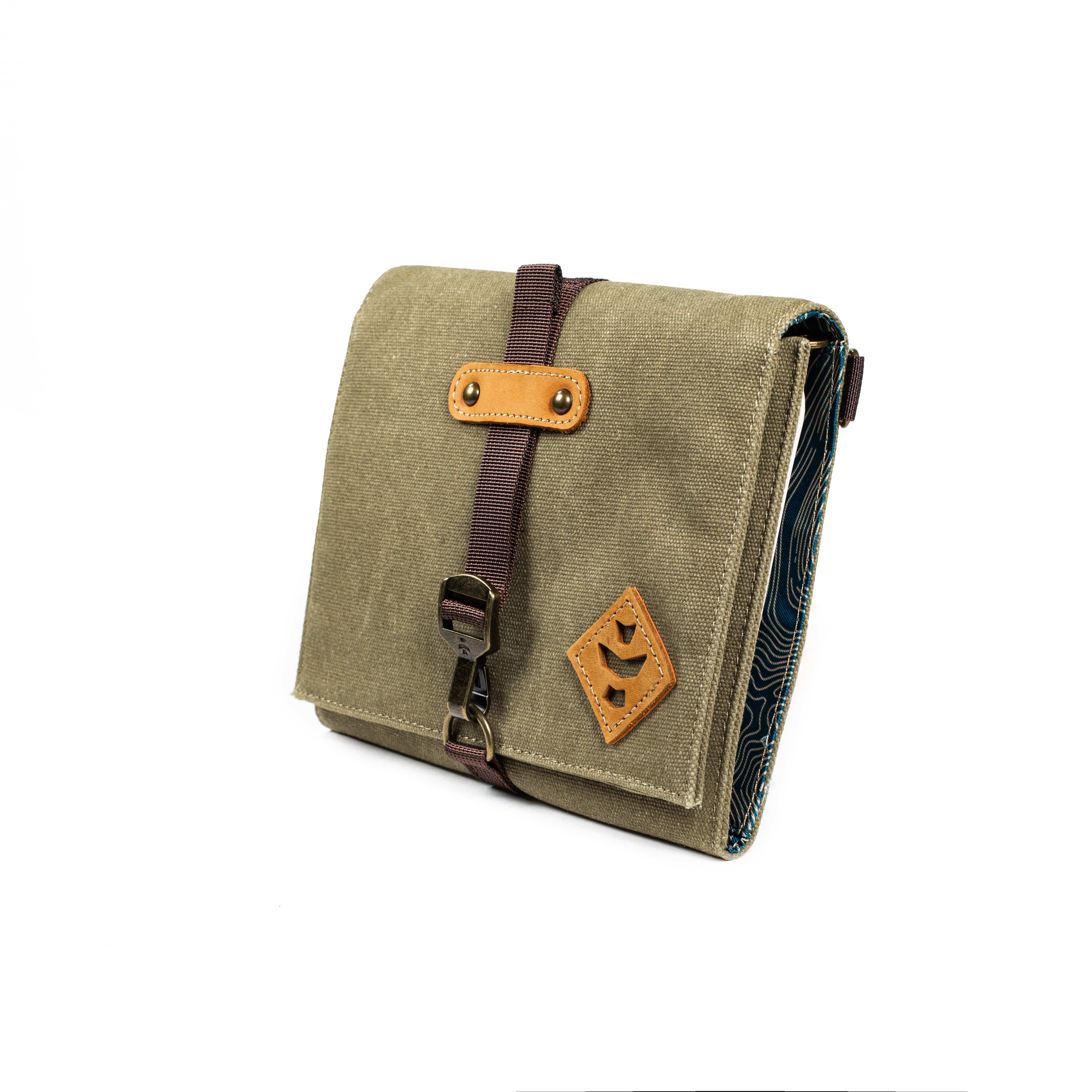 Front view of The Rolling Kit - Smell Proof Kit, a closed, dark green canvas pouch with a black strap and silver hardware.