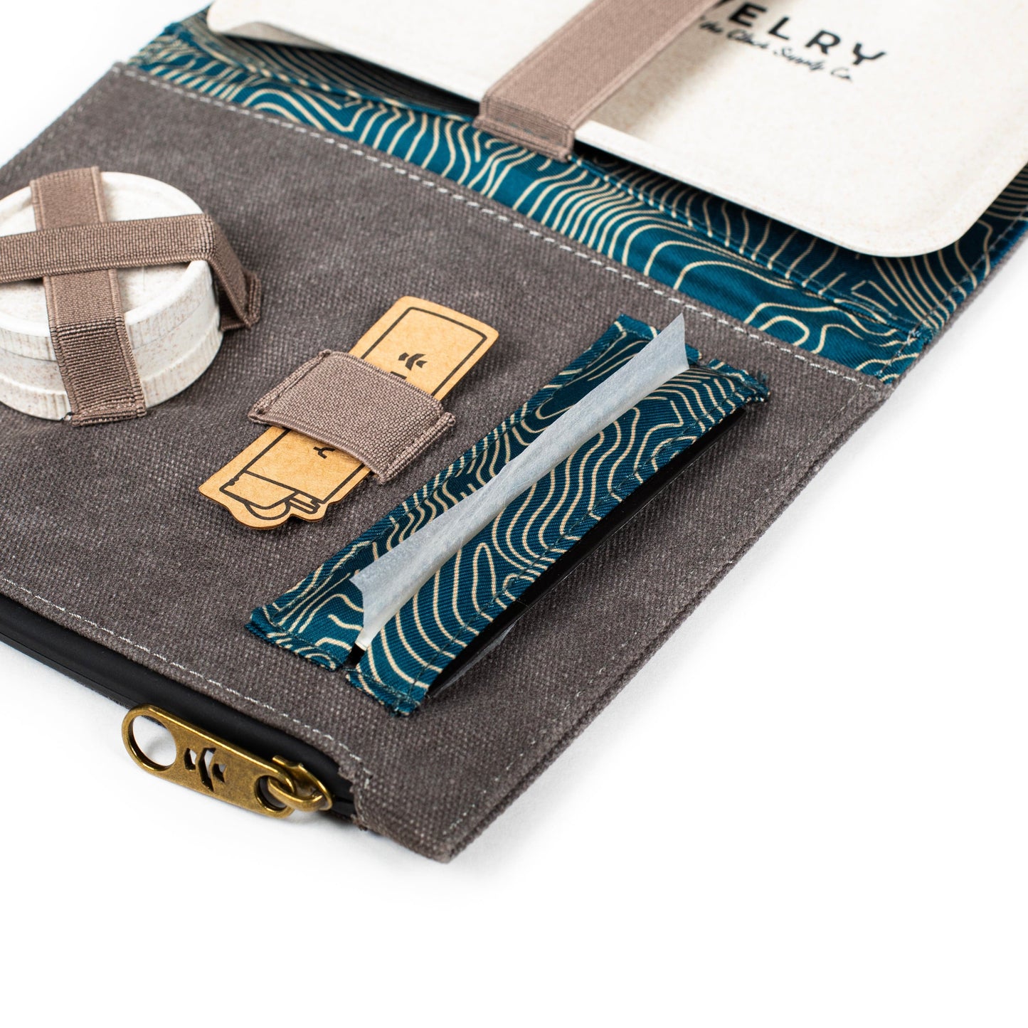 A close-up, angled view of The Rolling Kit - Smell Proof Kit, showing patterned fabric and small zipper pouches.