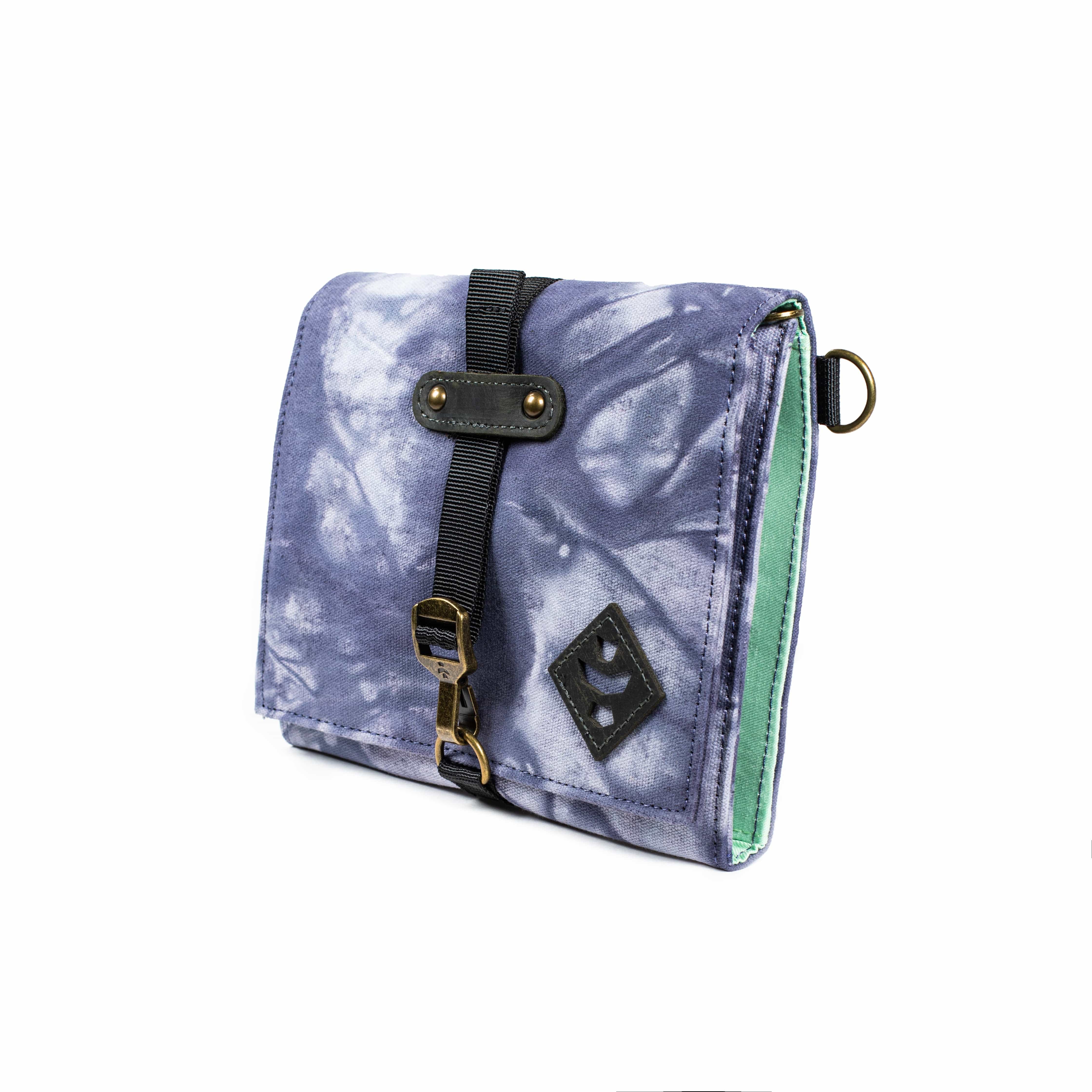 Front view of The Rolling Kit - Smell Proof Kit, a closed, patterned pouch with a black strap and metal clip, against a neutral backdrop.