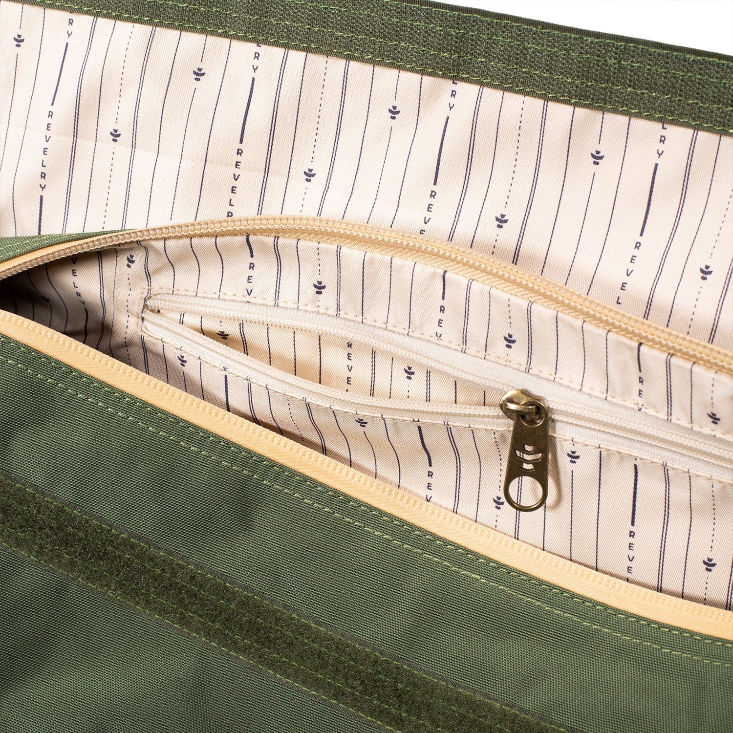 Top-down close-up of the green interior pocket and striped lining of The Weekender - Smell Proof Medium Duffle, showing a beige zippered pouch and metal zipper pull.
