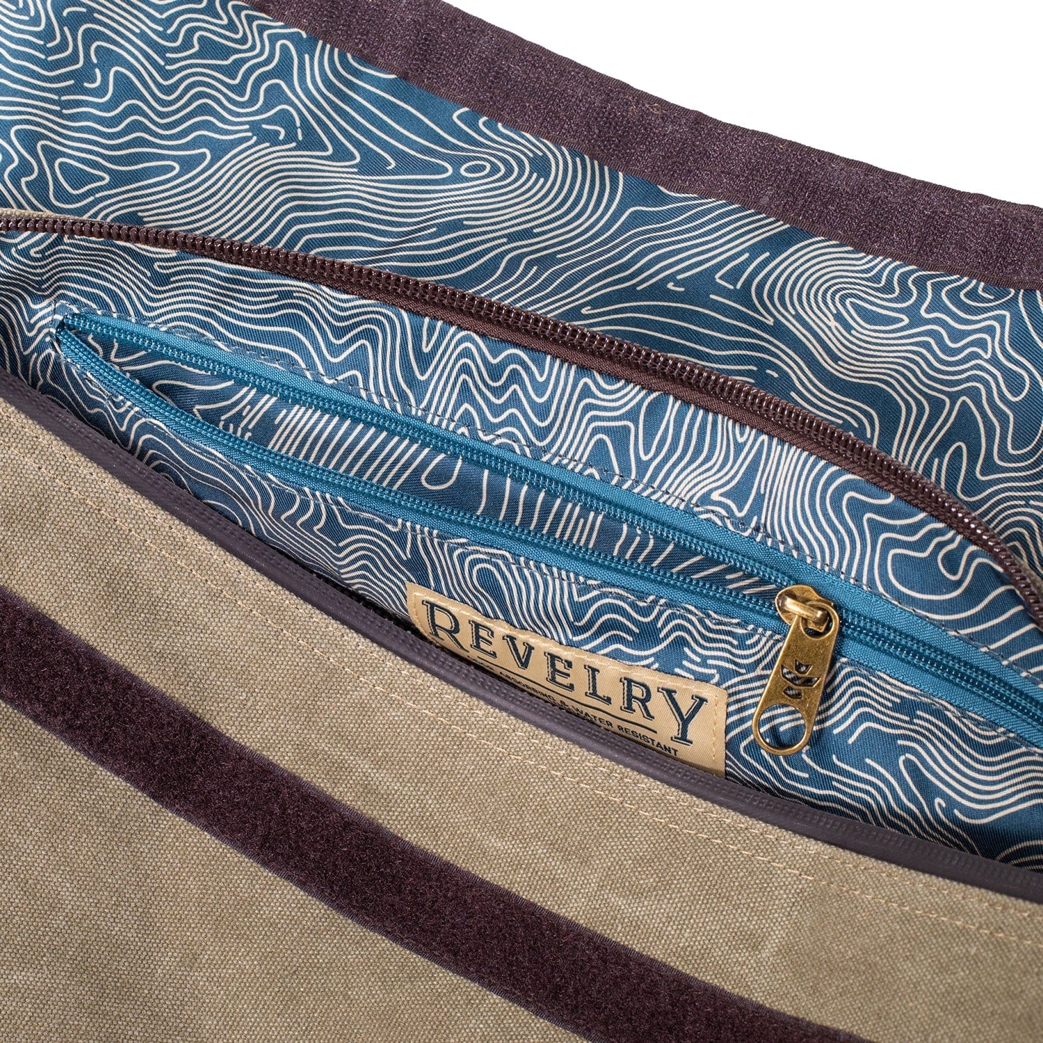 Close-up of the interior pocket of The Weekender - Smell Proof Medium Duffle showing blue and white contour-patterned lining, teal zipper, and brass pull.
