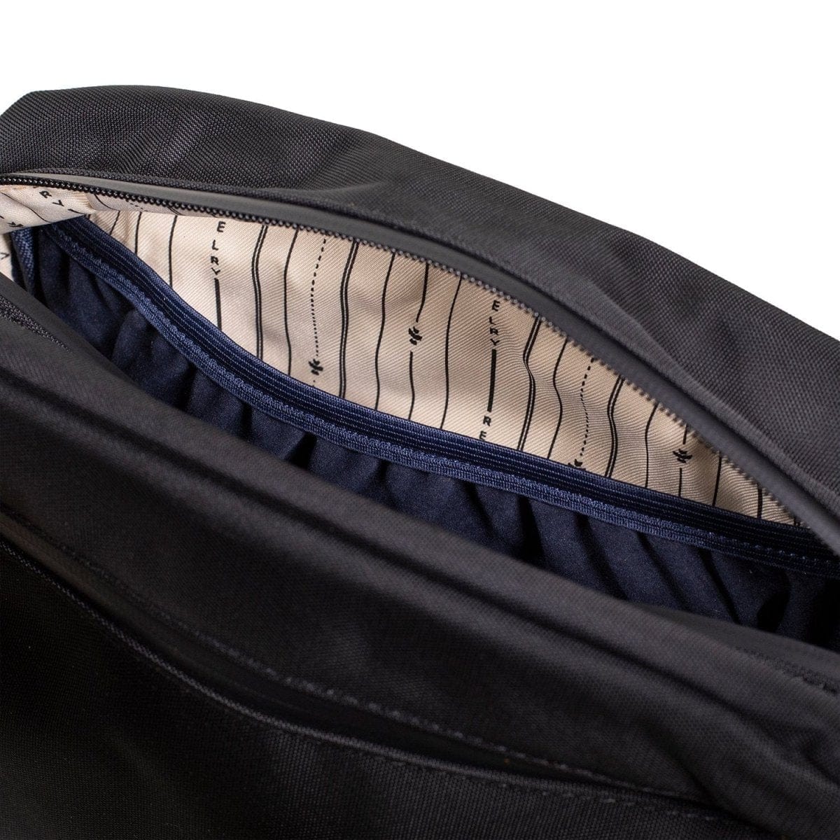 An open view of The Stowaway Smell Proof Toiletry Kit displaying a dark gray interior with visible stitching details.