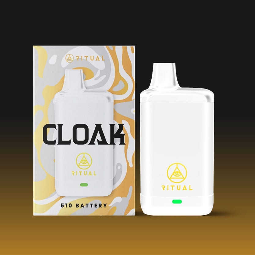 Front view of the white Ritual - Cloak 510 Variable Voltage Concealed Battery, angled against a blurred, warm-toned backdrop.