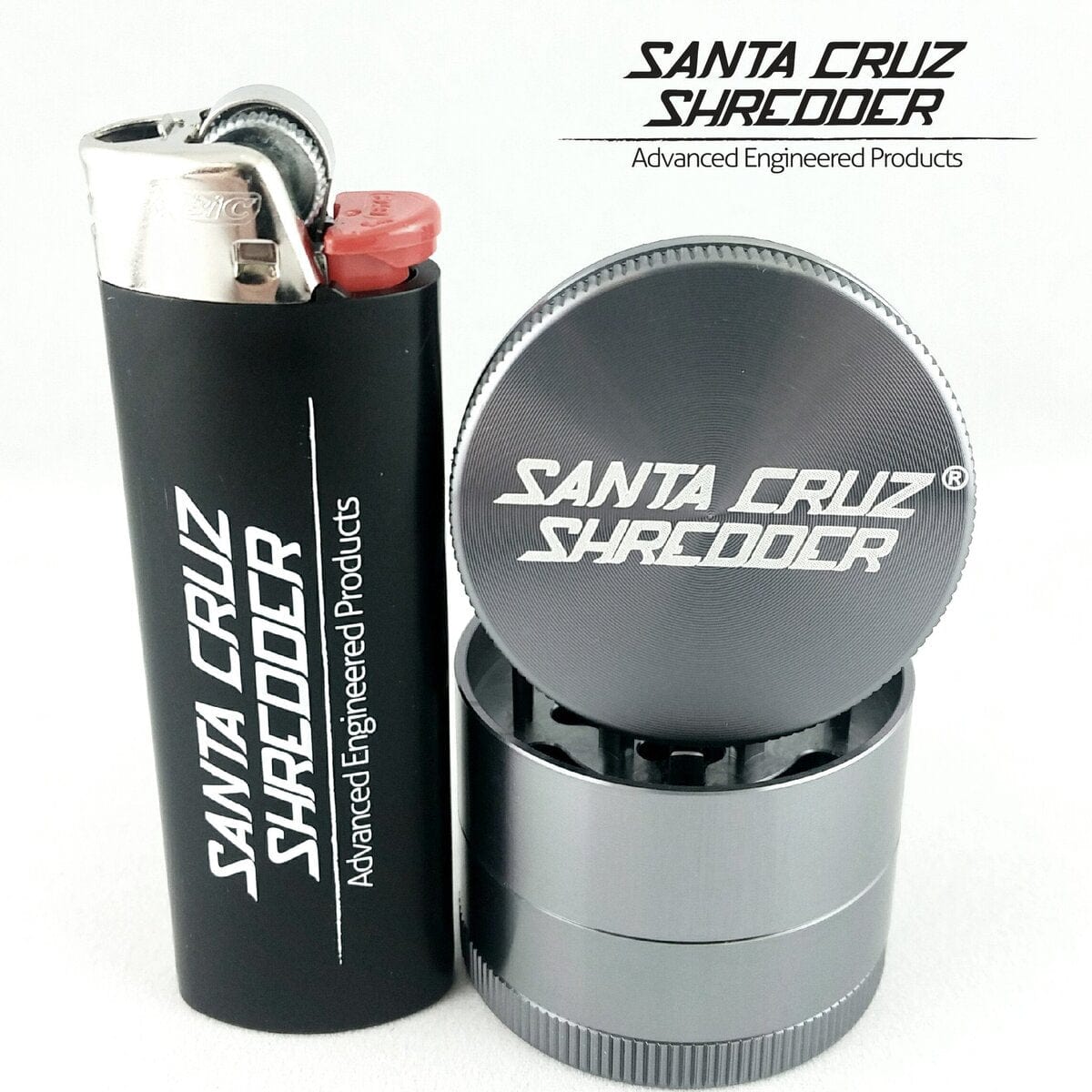 Close-up of the Santa Cruz Shredder 4 Piece Mini Grinder resting beside a lighter, showcasing its metallic finish.