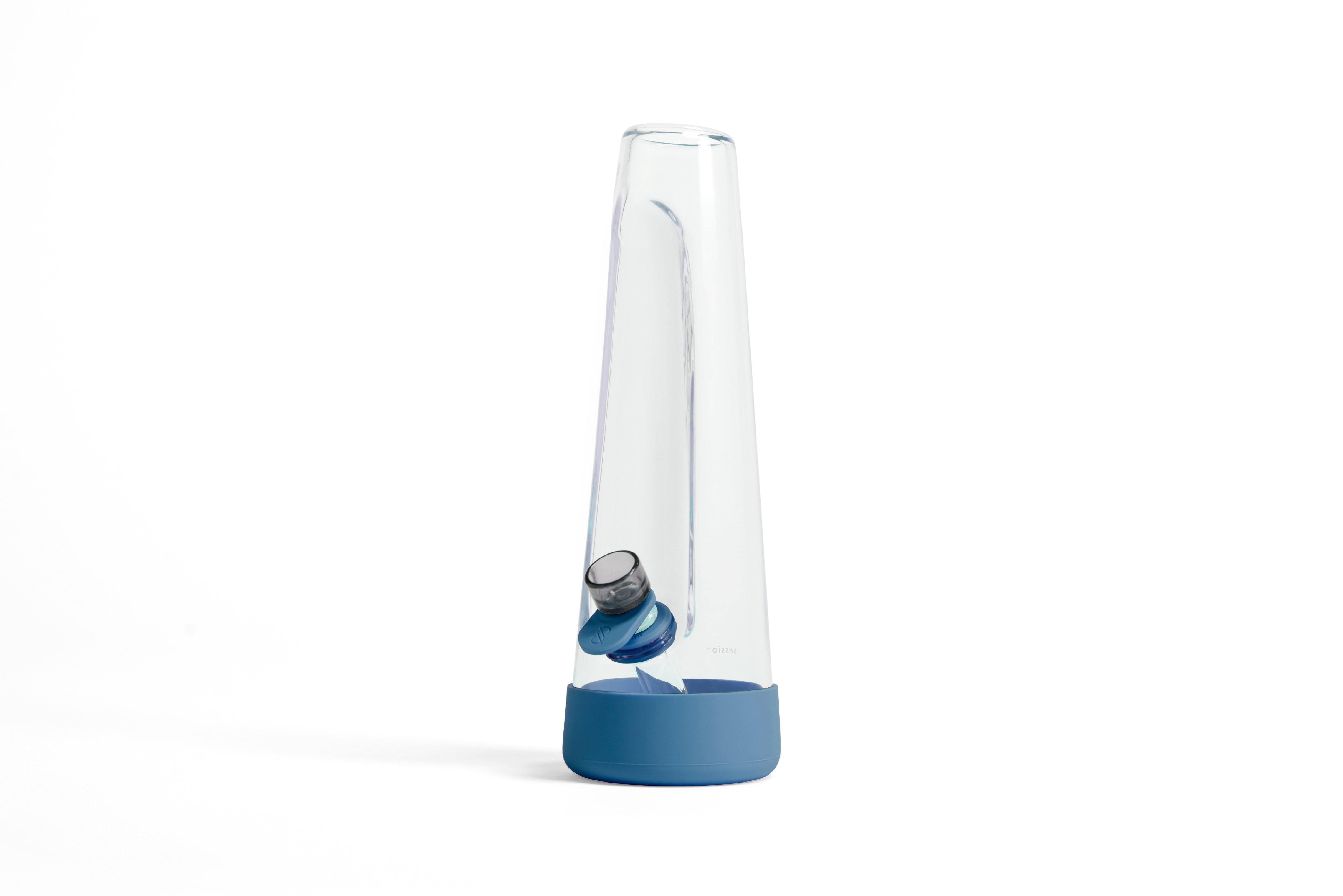 Angled close-up of the clear Session Goods Modern Bong with a blue silicone base and visible downstem against a white background