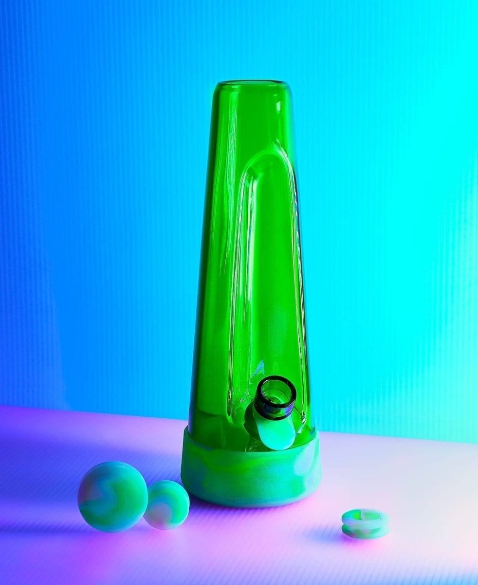 Front view of the Designer Bong GLOW, a green glass piece with spherical accents, set against a vibrant blue gradient background.
