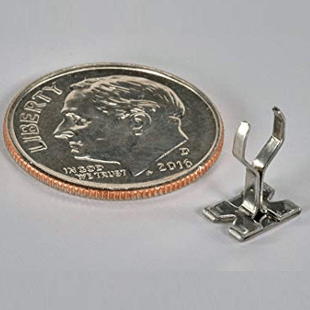A close-up, angled view of the Smojo Screen resting on a United States penny, highlighting its metallic construction.