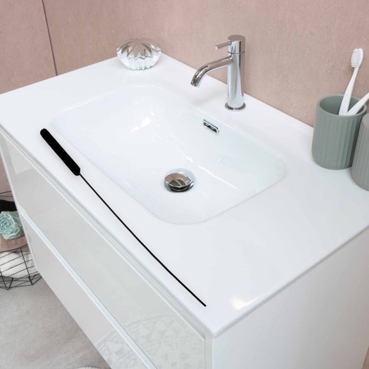 A front view of the Long High Quality Detail/Ice Catcher Brush positioned next to a toothbrush holder on a pink countertop.