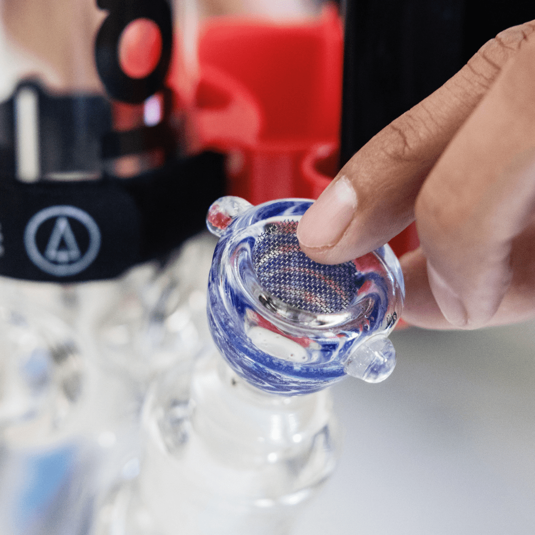 A close-up view shows a hand holding the Pure Titanium Mesh Screens, highlighting the fine mesh detail against a blurred background.